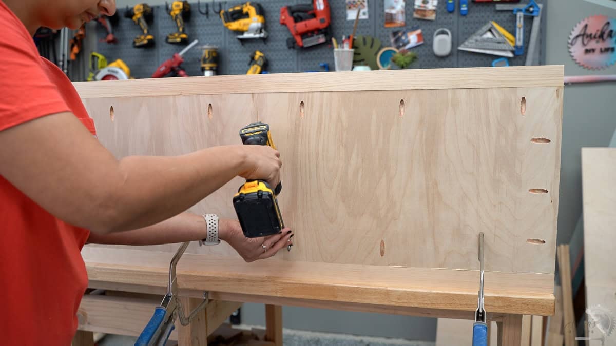 Attaching plywood to the legs to make the sides of the DIY dresser