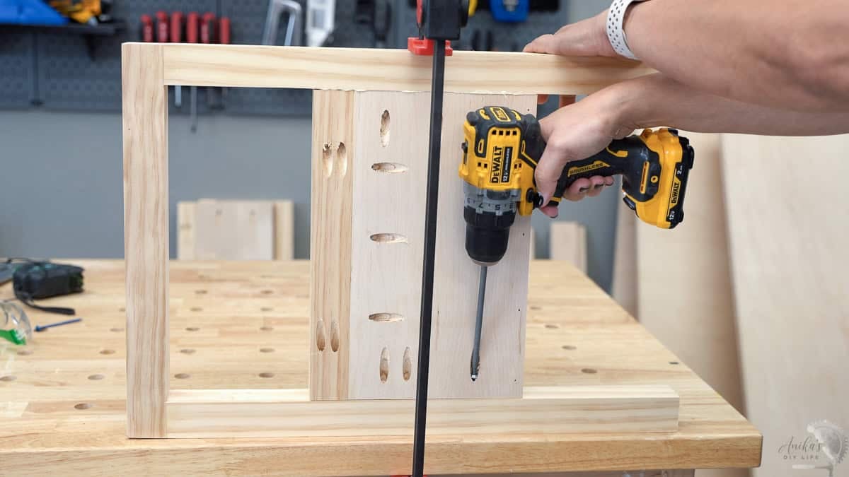 Attaching the panel to the side frame of the bench using pocket hole screws.