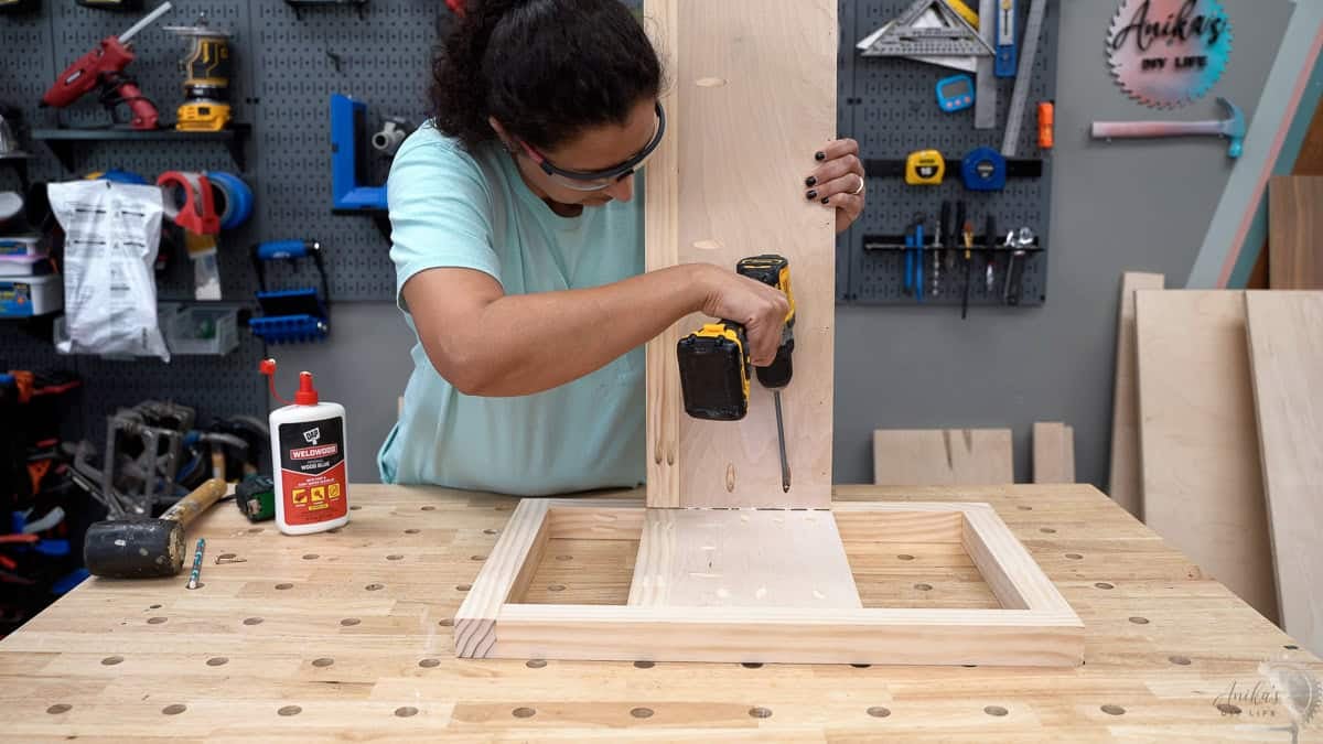 Attaching the long panel for the storage bench to the side frame using pocket hole screws
