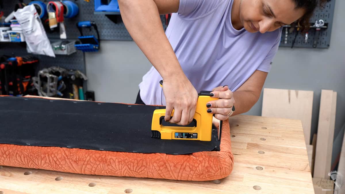 Woman attaching black fabric using a staple gun