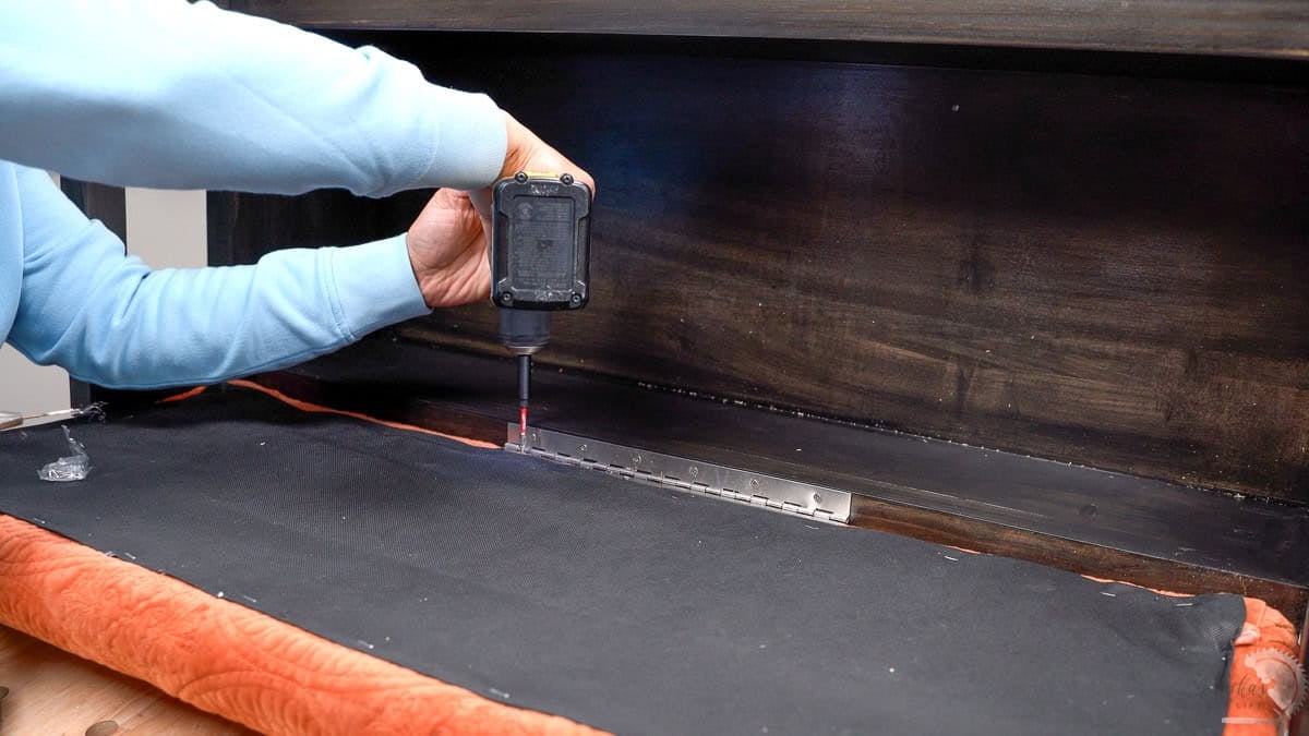 Attaching the upholstered lid to the storage bench