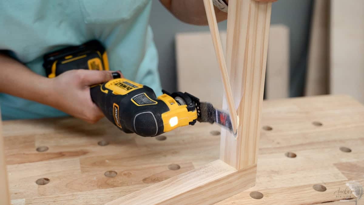 Cutting off the dowel used to fill the pocket holes using a multitool