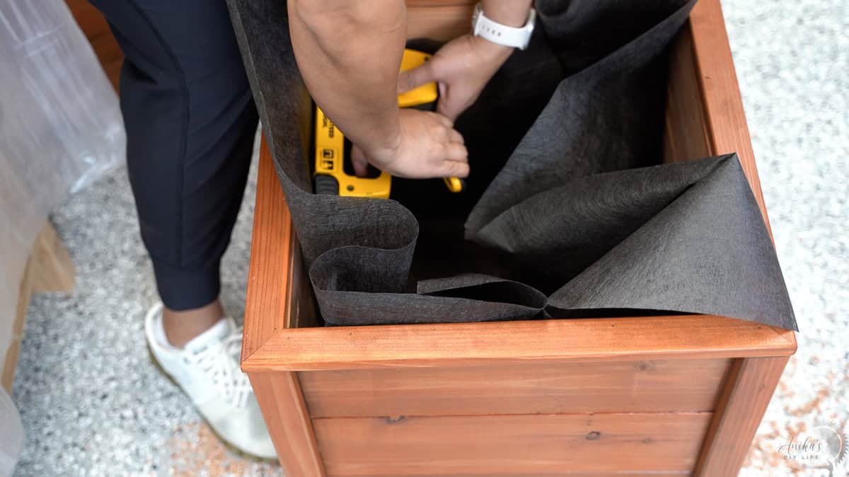 Attaching the landscape fabric inside the planter