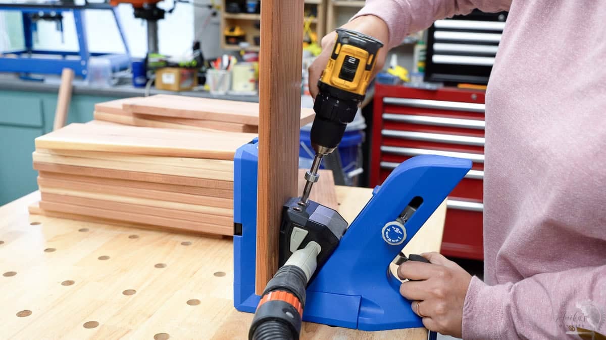 Woamn making pocket holes in the 1x6 boards on a Kreg 720