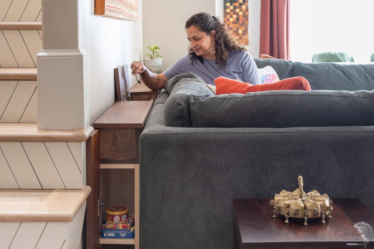 Anika using the charger in the diy sofa table with charging station and storage