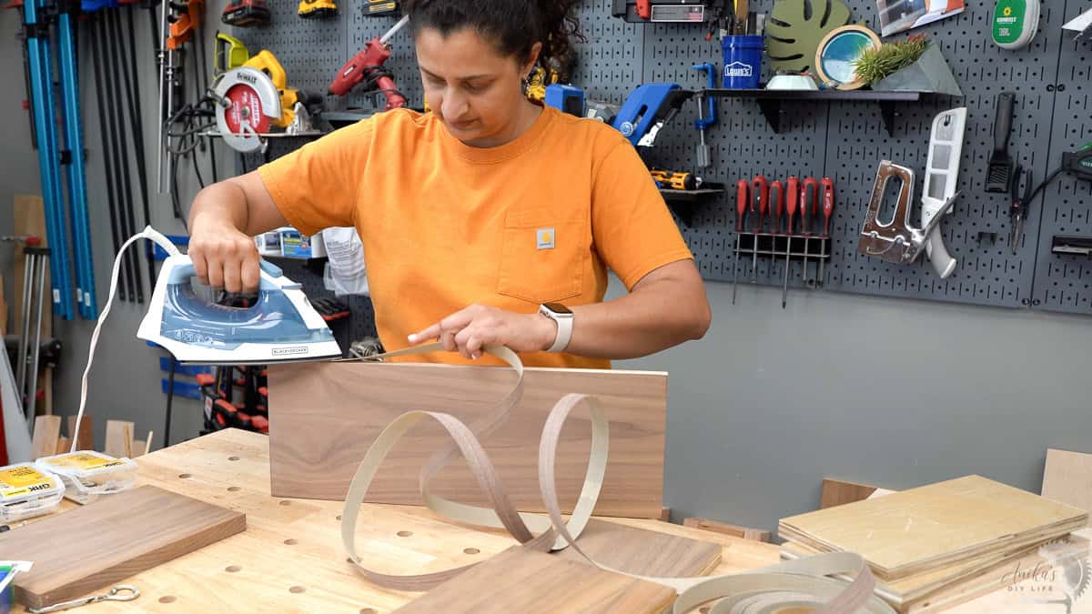 Anika applying edge banding to the walnut plywood.