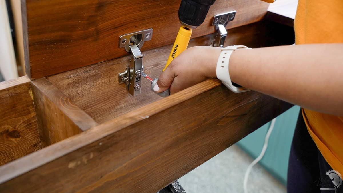 Installing the hinges for the doors in the DIY Sofa table.