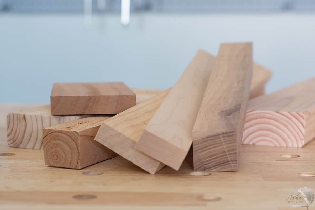 pile of hardwoord and softwood boards on a workbench in the workshop