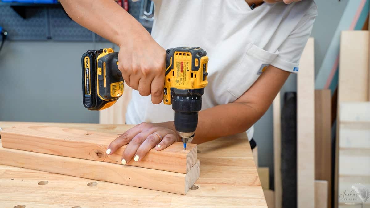 Woman drillin pilot hole in wood