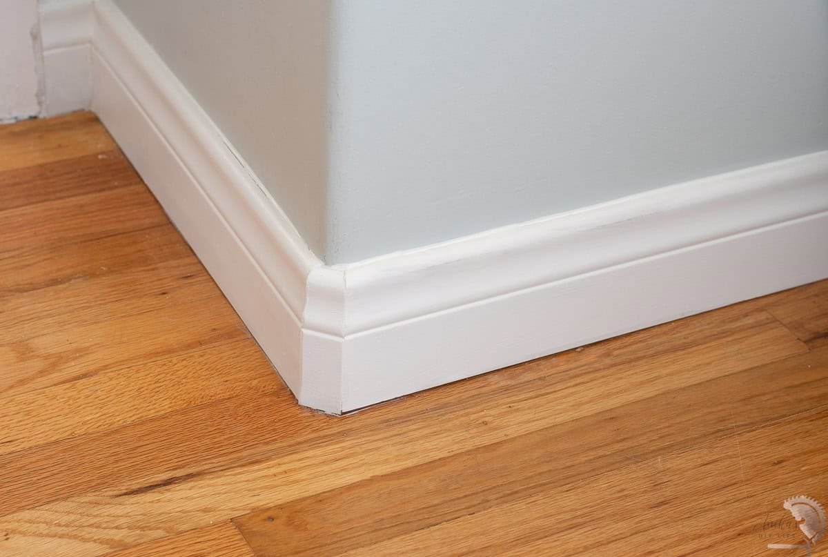 Bullnose corner with modern baseboards in room with blue walls and wood floors
