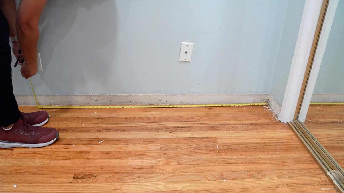 measuring the distance from the wall for the baseboards